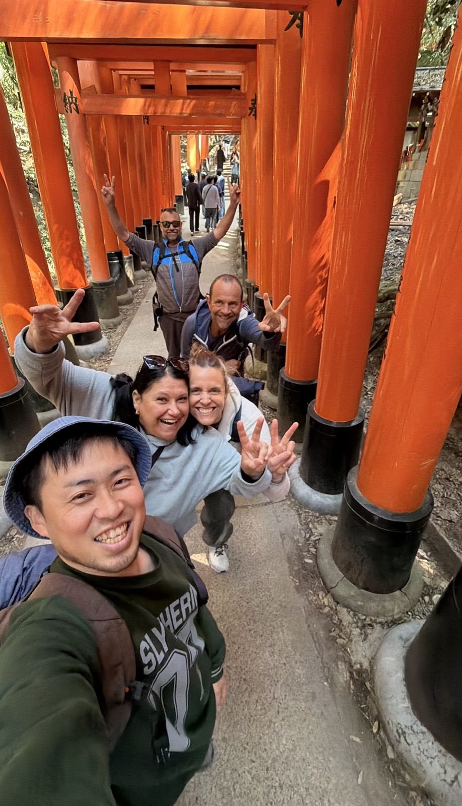 A smiling group among the red torii gates in Kyoto